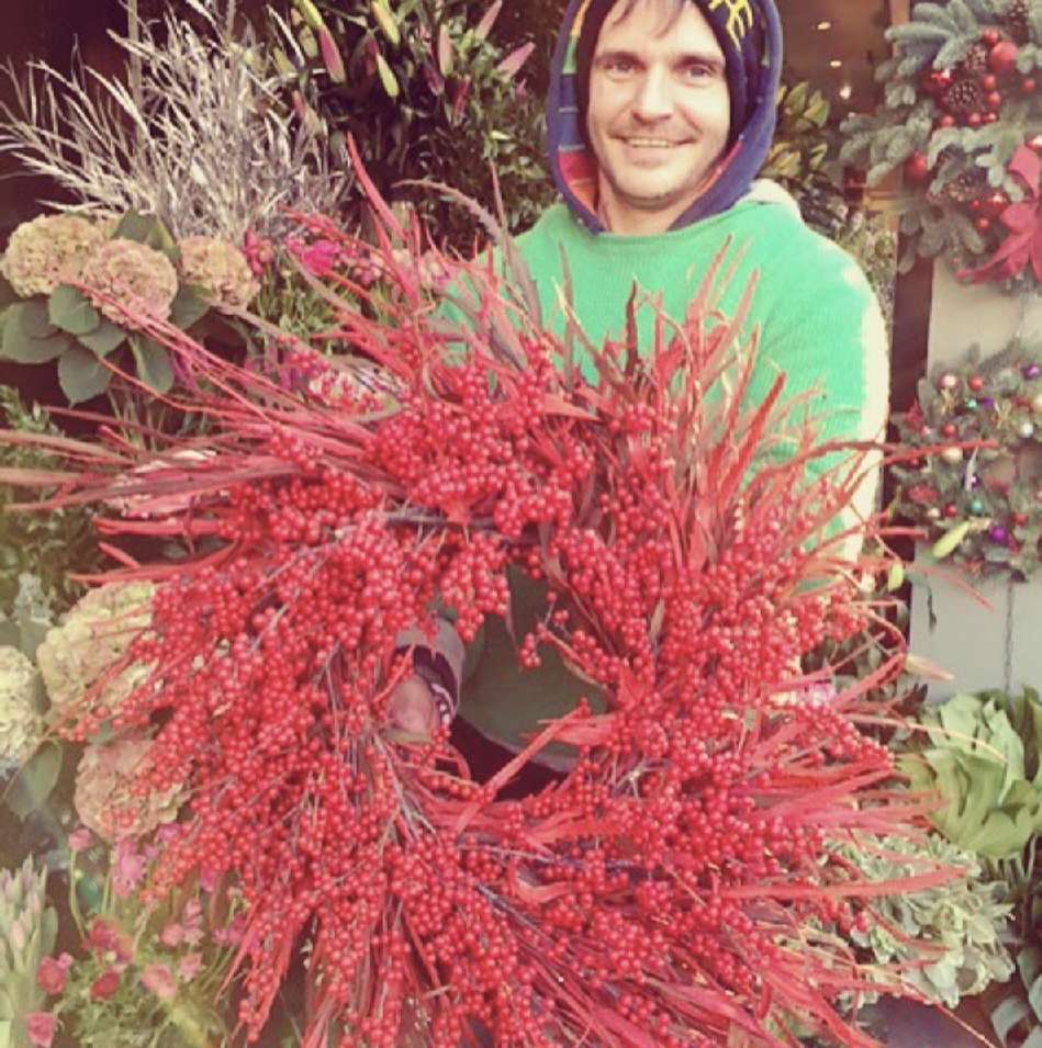 David at the flower stand with a large bunch of red seasonal berries